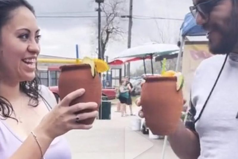 Pareja brindando con cantaritos en Azteca Farmers Market
